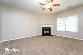 Lawrenceville house for rent - A spacious room with a fireplace and a ceiling fan.