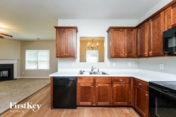 Lawrenceville house for rent - A kitchen with wooden cabinets and a black dishwasher.