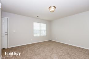 Charlotte house for rent - A spacious room with a carpeted floor and a window letting in natural light.