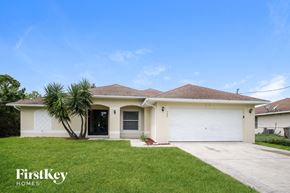 Lehigh Acres house for rent - a white house with a palm tree in the yard