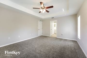 Lehigh Acres house for rent - a living room with carpet and a ceiling fan