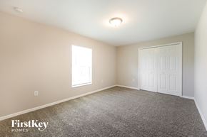 Lehigh Acres house for rent - a bedroom with a carpeted floor and a white door