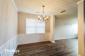Lawrenceville house for rent - an empty dining room with wood floors and a chandelier