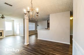 Lawrenceville house for rent - an empty living room and kitchen with wood floors and a chandelier