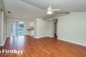 Orange City house for rent - an empty living room with wood floors and a ceiling fan
