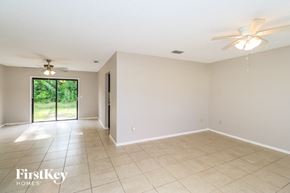 Palm Bay house for rent - A spacious room with a sliding glass door leading to a green outdoor area.