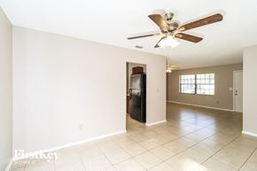 Palm Bay house for rent - A spacious room with a ceiling fan and a refrigerator.