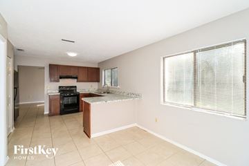 Palm Bay house for rent - A kitchen with a stove top oven and a sink.