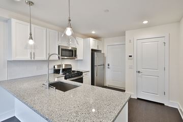 Philadelphia apartment for rent - a kitchen with white cabinets and a granite counter top