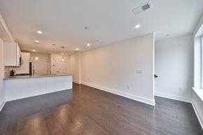 Philadelphia apartment for rent - the living room and kitchen of an empty home with white walls and wood flooring
