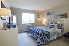 Madison Heights apartment for rent - A bedroom with a bed, nightstand, and lamp.