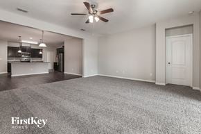 Jacksonville house for rent - A spacious room with a ceiling fan and a carpeted floor.