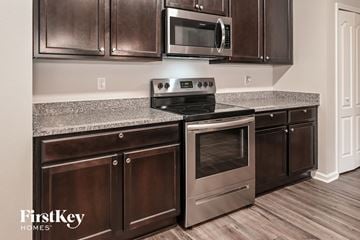 Jacksonville house for rent - A modern kitchen with a stove top oven and microwave.