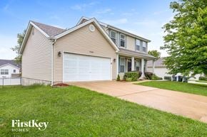 O'fallon house for rent - a beige house with a white garage door and a driveway