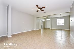 Cape Coral house for rent - an empty living room with a ceiling fan