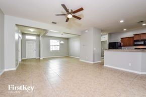 Cape Coral house for rent - an empty kitchen and living room with a ceiling fan