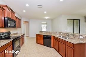Cape Coral house for rent - a kitchen with granite counter tops and wooden cabinets
