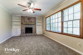 Stone Mountain house for rent - A room with a fireplace and a ceiling fan.