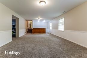 Stone Mountain house for rent - A spacious room with a carpeted floor and a wooden door at the end.