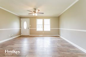 Clermont house for rent - an empty living room with white walls and a ceiling fan