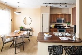 Council Bluffs apartment for rent - A kitchen with a table and chairs in front of it.
