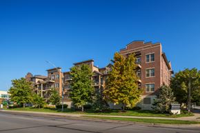 Omaha apartment for rent - A large apartment building with a green lawn in front.