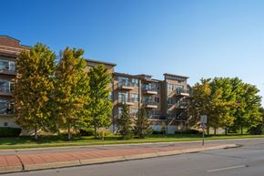 Omaha apartment for rent - A large apartment building with a red brick sidewalk in front of it.