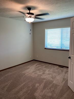Lincoln house for rent - a bedroom with a ceiling fan and a window