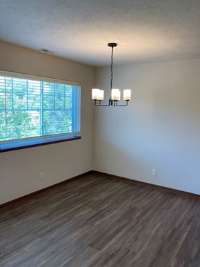 Lincoln house for rent - an empty living room with a large window and wooden floors