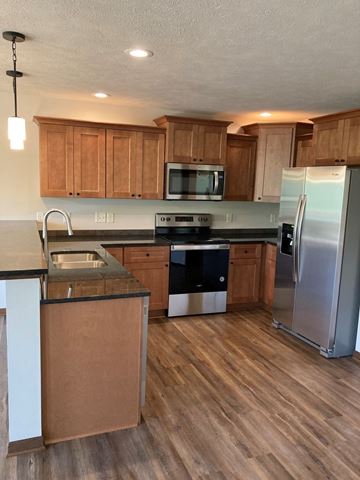 Lincoln house for rent - a kitchen with wooden cabinets and stainless steel appliances