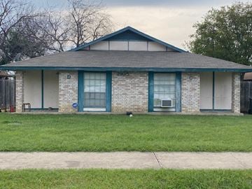 Killeen apartment for rent - a small brick house with blue doors and a lawn