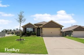 Conroe house for rent - a house with a driveway and a lawn