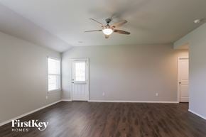 Conroe house for rent - a living room with white walls and a ceiling fan