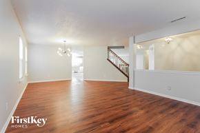 Plainfield house for rent - A spacious room with wooden floors and a staircase.