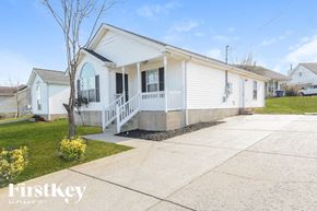 La Vergne house for rent - A white house with a porch and a tree in front of it.