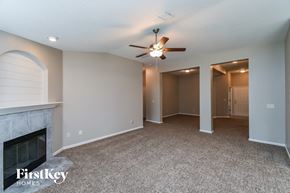 Jacksonville house for rent - a living room with a fireplace and a ceiling fan