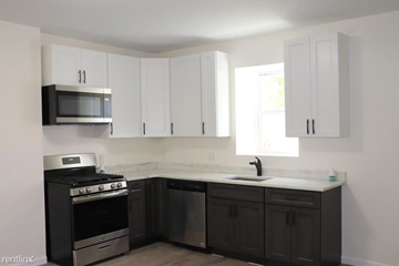 Philadelphia apartment for rent - a kitchen with white cabinets and a stove and a microwave