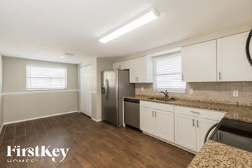 Port Richey house for rent - A kitchen with a refrigerator, cabinets, and a countertop.