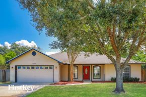 Jacksonville house for rent - a home with a lawn and trees in front of it