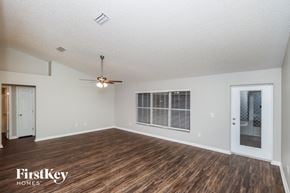 Palm Bay house for rent - A spacious room with wooden flooring and a ceiling fan.