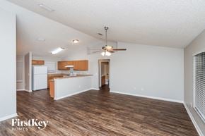 Palm Bay house for rent - A spacious room with wooden floors and a ceiling fan.