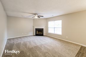 Summerville house for rent - an empty living room with a fireplace and a ceiling fan