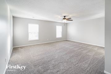 Summerville house for rent - a spacious living room with carpet and a ceiling fan