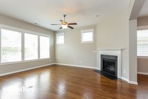 Belmont house for rent - A spacious living room with a fireplace and a ceiling fan.