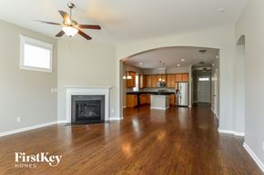 Belmont house for rent - A spacious living room with a fireplace and a ceiling fan.