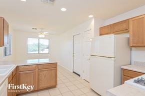 Tucson house for rent - a kitchen with white appliances and wooden cabinets