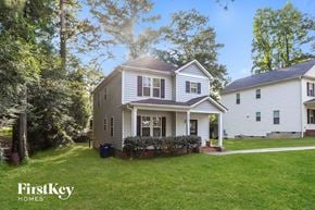 Raleigh house for rent - A house with a well-kept lawn and trees in the background.
