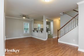 Raleigh house for rent - A spacious room with wooden floors and a staircase on the right side.