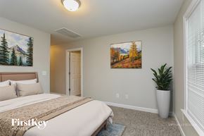 Raleigh house for rent - A bedroom with a bed, a painting, and a plant.