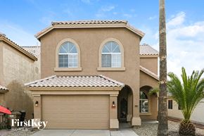 Peoria house for rent - a house with a garage door and a palm tree